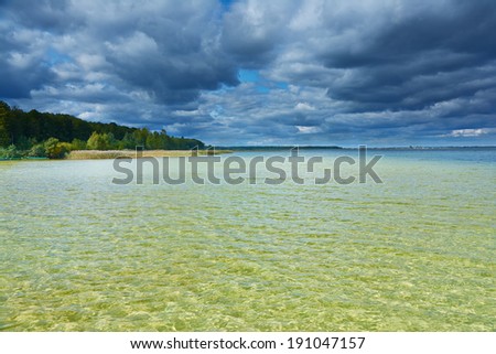 Landscape - Storm clouds over lake with clear water and sandy bottom