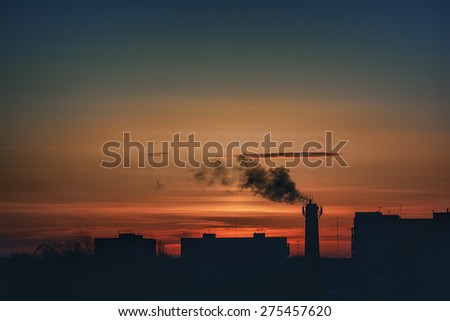 Evening cityscape - silhouettes of rooftops and boiler tubes
