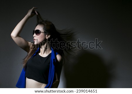 A fashion woman with windy hair and the shadow is reflected on the wall