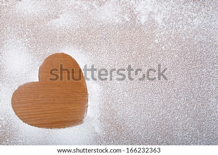 Heart in snow on a wooden background, a Valentine\'s Day theme