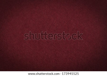 Maroon paper background or texture with vignette