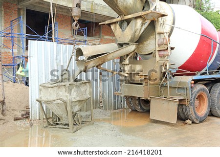 pouring concrete from automobile mixer into crane bucket