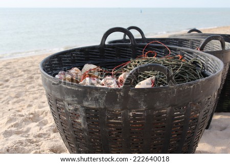 Closeup of sea shells in plastic baskets on beach.