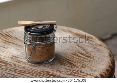 Closeup of brown sugar in sugar bowl on wooden table.