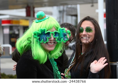 BOSTON, MASSACHUSETTS - MARCH 16: A pair of young women wear festive green glasses during a Saint Patrick\'s day parade. One woman (left) also wears a funny green wig. The parade was held March 16, 2008 in Boston, Massachusetts.