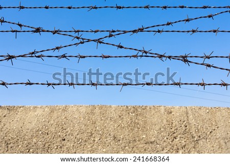 Barbed wire wire on the blue sky background.