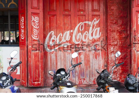 INDIA, PUNE, 25 November 2014: Red door with logo Coca-Cola and motorcycles.