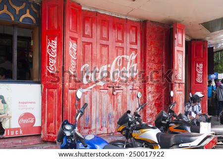 INDIA, PUNE, 25 November 2014: Red door with logo Coca-Cola and motorcycles.