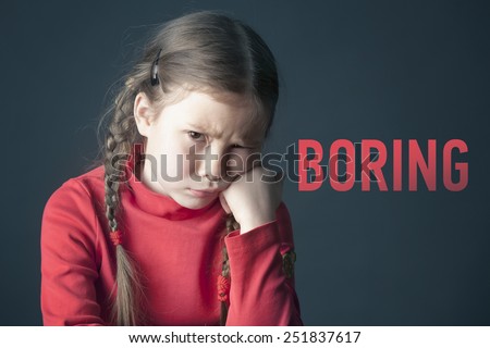 Sad pensive girl with pigtails and with the inscription Boring