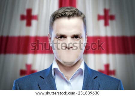 Symbol of censorship and freedom of speech: a young man without a mouth on a background of the national flag of Georgia