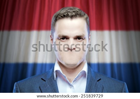 Symbol of censorship and freedom of speech: a young man without a mouth on a background of the national flag of Netherland