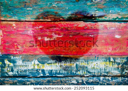 Peeled multicolor painted wood texture, picture of red heart fof