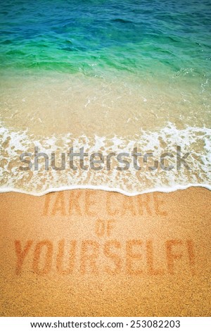 Surf wave on a inscription Take Care of Yourself! on a sea beach