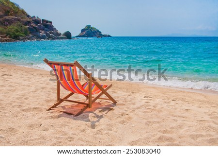Lounge chair n the beach with rocks on background