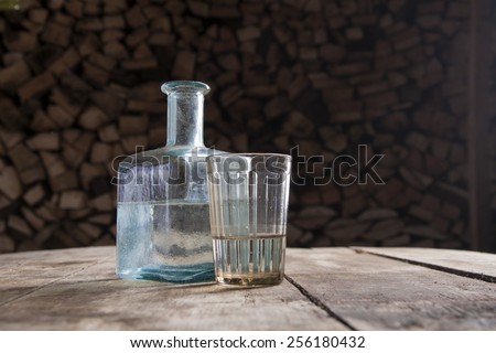 Bottle and glass of moonshine or vodka on the table