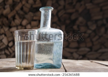 Bottle and glass of moonshine or vodka on the table