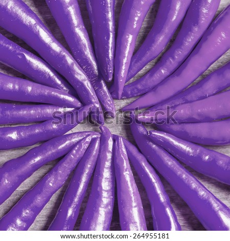 The composition of purple hot peppers on a wooden table