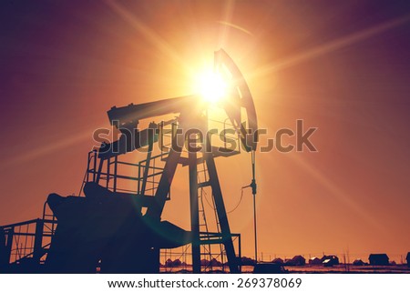 Oil pump on background of red (orange) sky - instagram style
