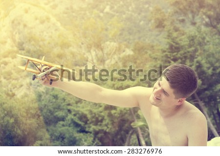Toy airplane in hand of young man- a symbol of travel and dreams