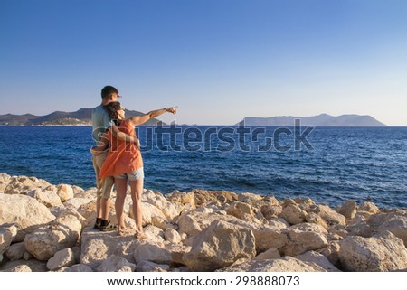 Man and woman greet  the sun on the beach