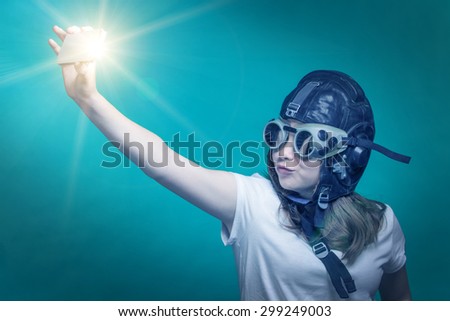 Girl in pilot helmet meking a selfie by smartphone