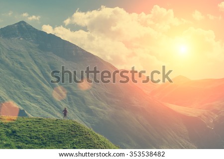 Young girl standing on the top up against the sky and mountain
