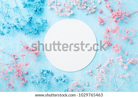 Wedding mockup with white paper list and flowers on blue pastel table top view. Beautiful floral pattern. Flat lay style. Spring Woman day card.