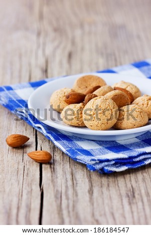 Sweet almond cookies in plate on wooden rustic background, traditional italian biscuit