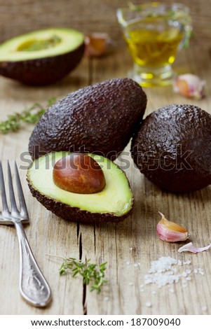 Avocado with olive oil, herb thyme, garlic and sea salt on a wooden rustic board