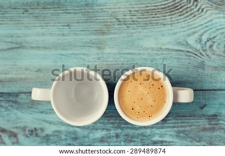Empty and full cup of fresh coffee on vintage wooden blue table