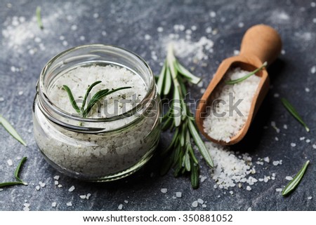 Sea salt scented herb rosemary on black stone background, vintage style