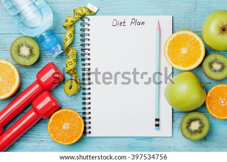 Diet plan, menu or program, tape measure, water, dumbbells and diet food of fresh fruits on blue background, weight loss and detox concept, top view