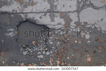 hole in asphalt with puddles