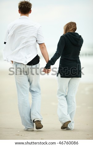 people walking on the beach. stock photo : two young people