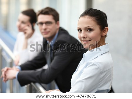 group of three persons talking on the corridor in office space with laptop, potrait