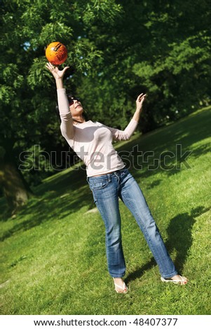 young woman in park catching playing with ball