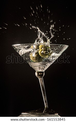 Clear martini with an olive splash
