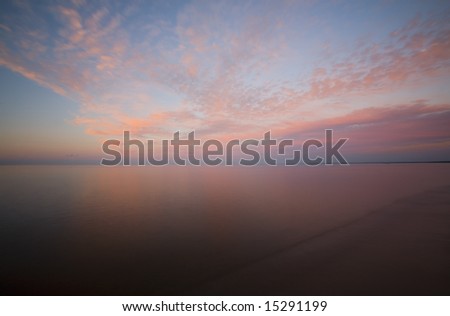 Sunset sky with clouds over the smooth water of Lake Superior.
