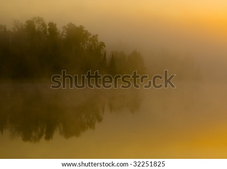 Shoreline hidden in fog at sunrise on Boulder Lake in Northern Minnesota