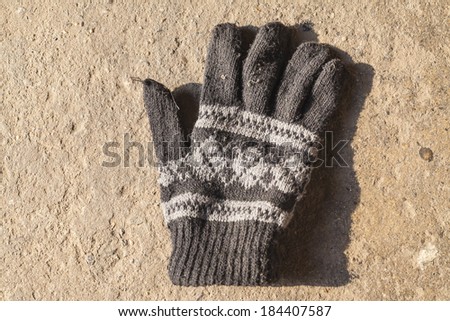 Old Knit Gloves with Pattern on concrete floor