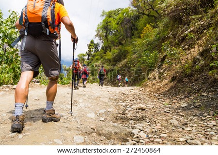 A group of people trekking on dirt road in Nepal