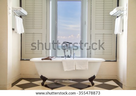 Luxury classic bathtub in bathroom with relaxing ambient and window  with scenic sea view