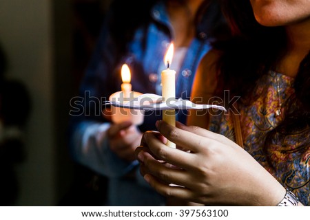 Closeup of people holding candle vigil in darkness expressing and seeking hope