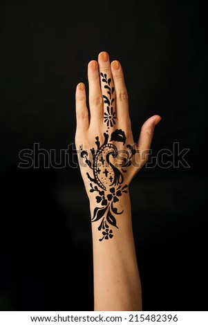 hand with mehendi on black background