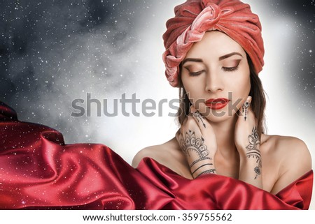 beautiful stylish woman in oriental style with mehendy wearing in turban . night. sky with stars.