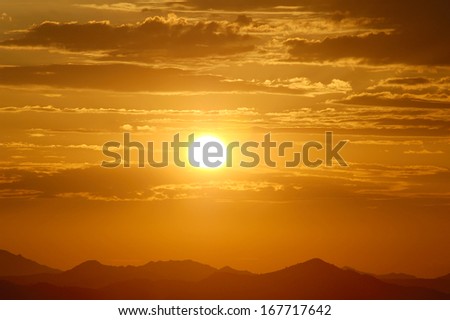 Setting sun over hills in the desert