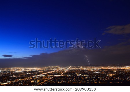 Phoenix city lights at dusk with a lightning strike
