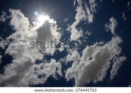 Fair weather clouds with sun and deep blue sky