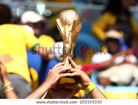 RIO DE JANEIRO, BRAZIL - July 04, 2014: Soccer fans showing a fake World Cup Trophy during the World Cup Quarter-finals game between France and Germany at Maracana Stadium. No Use in Brazil.