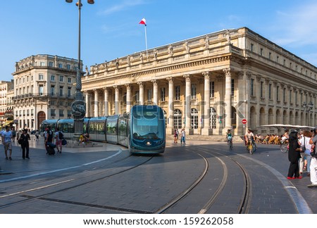 Bordeaux, France - July 14: Modern Tram On The Place De La Comedie In Bordeaux, France On July 14, 2013. The Ground-Level Power Supply Was Invented By Apc Company Especially For The Bordeaux Tramway